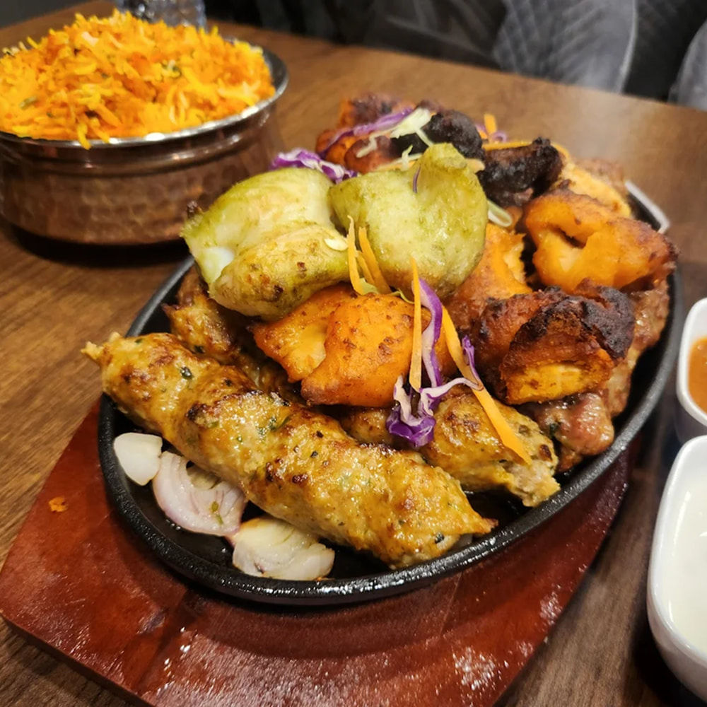 Mixed grilled barbecue platter served with flavorful biryani rice