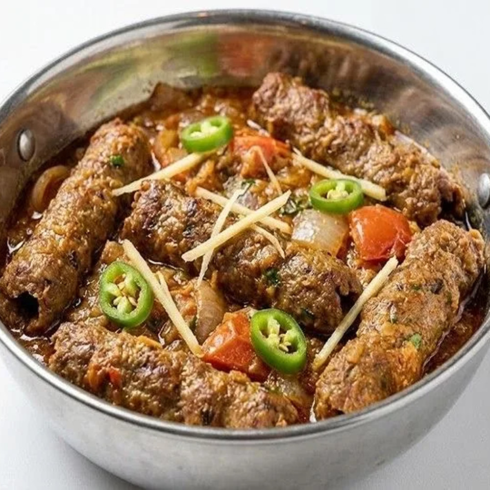 Traditional spicy meat curry garnished with fresh green chilies