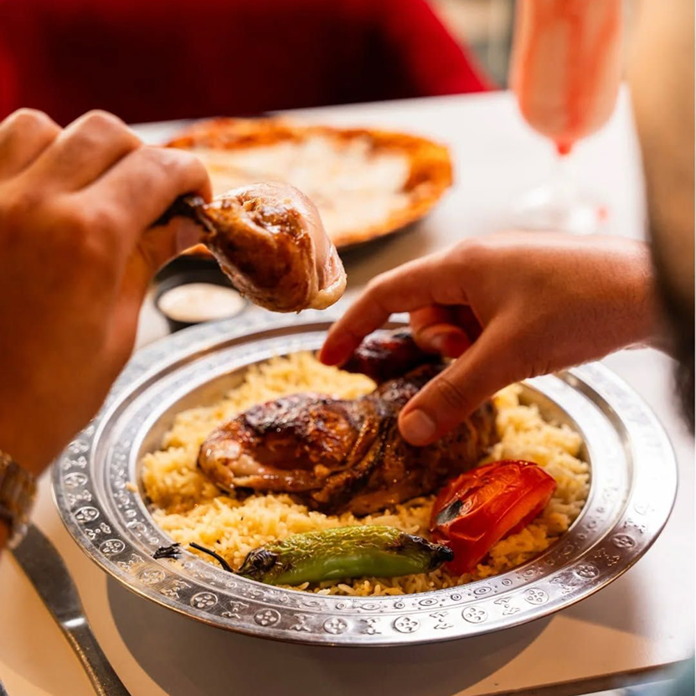 Traditional Arabic chicken rice platter served with grilled vegetables