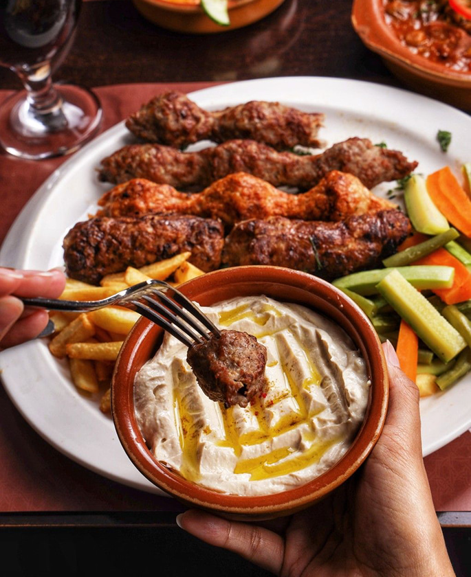 Arabic grilled kebabs served with hummus and fresh vegetables