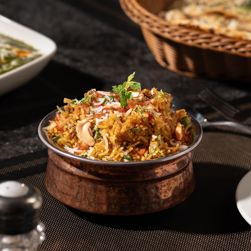 Flavorful Arabic rice dish garnished with nuts and herbs