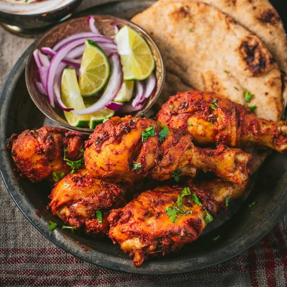 Spicy Indian tandoori chicken served with naan and onions