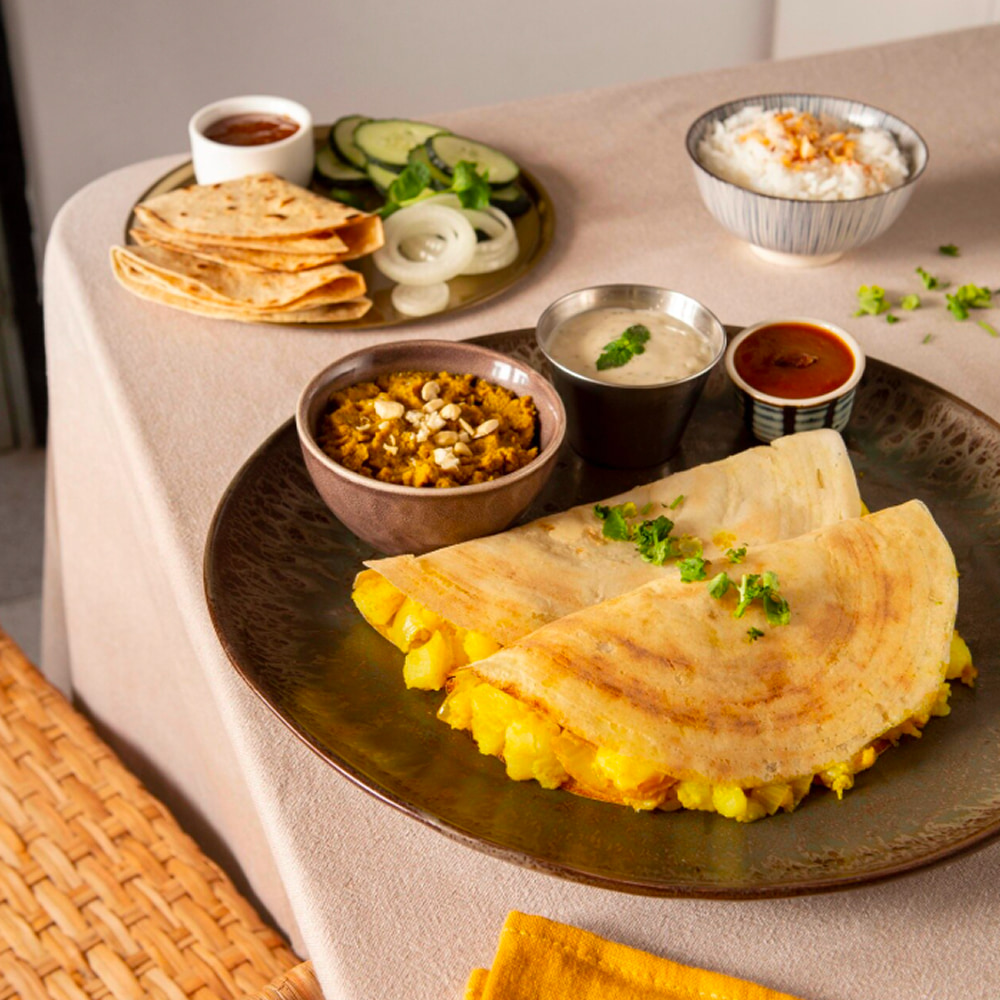 Traditional masala dosa served with chutneys and fresh sides