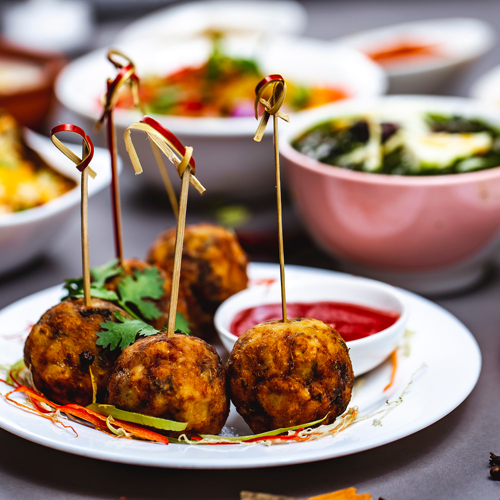 Crispy fried appetizer balls served with flavorful dipping sauce