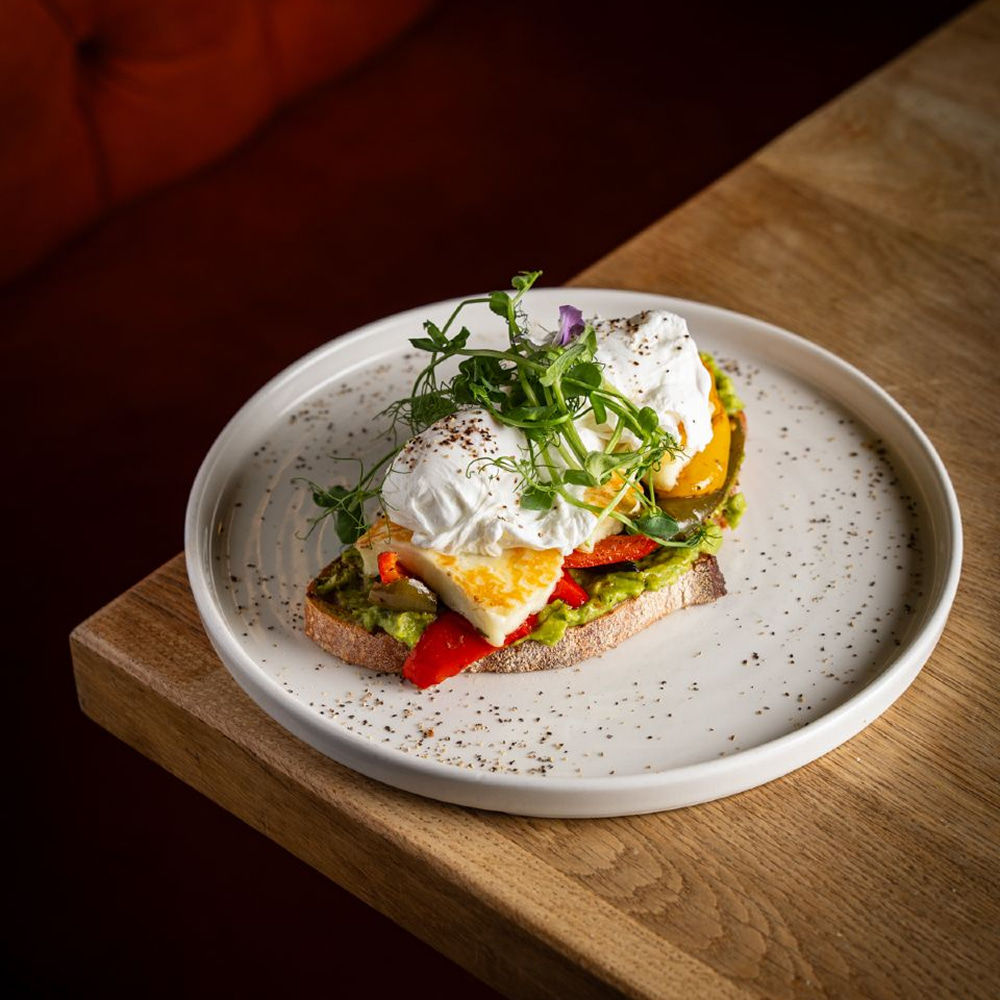 Poached eggs on toast topped with fresh greens