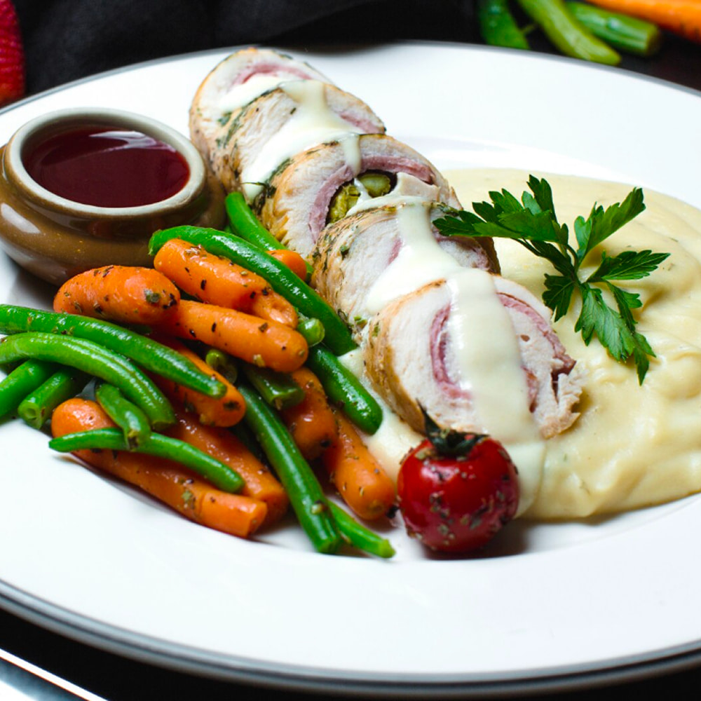 Stuffed chicken breast with mashed potatoes and fresh vegetables