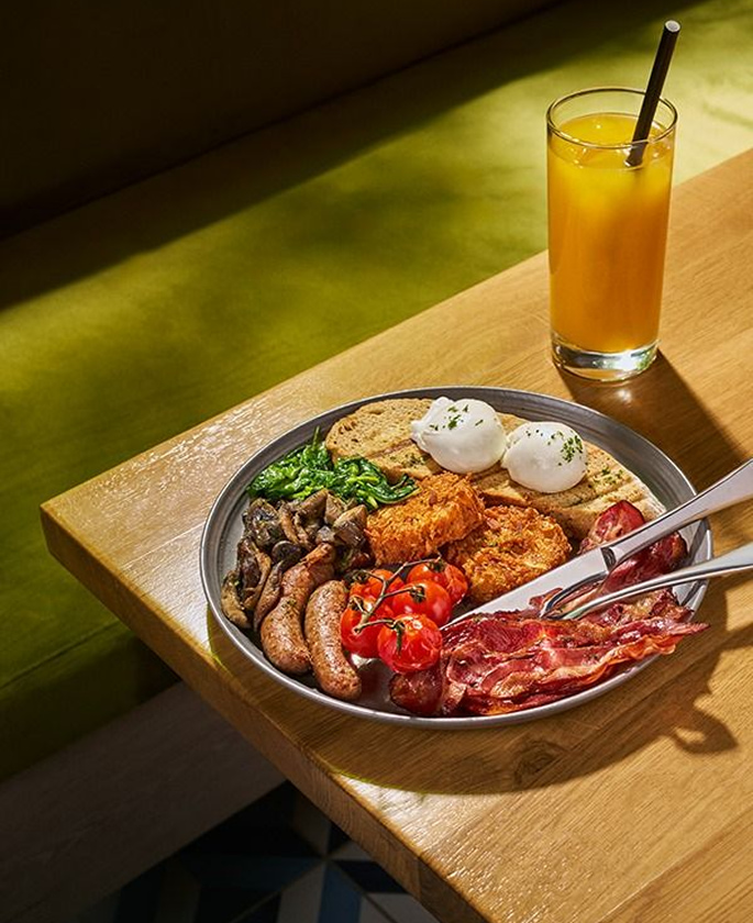 Full English breakfast served with juice and poached eggs