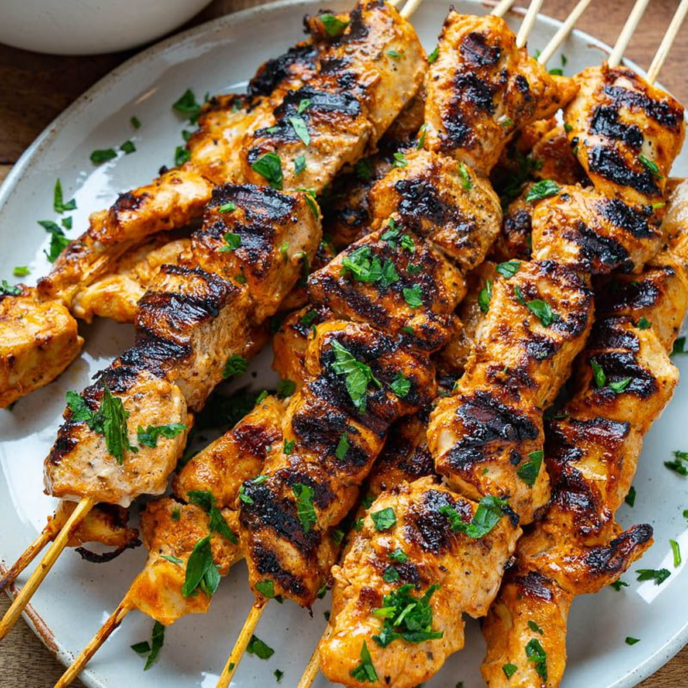 Grilled chicken skewers served with fresh herbs and spices