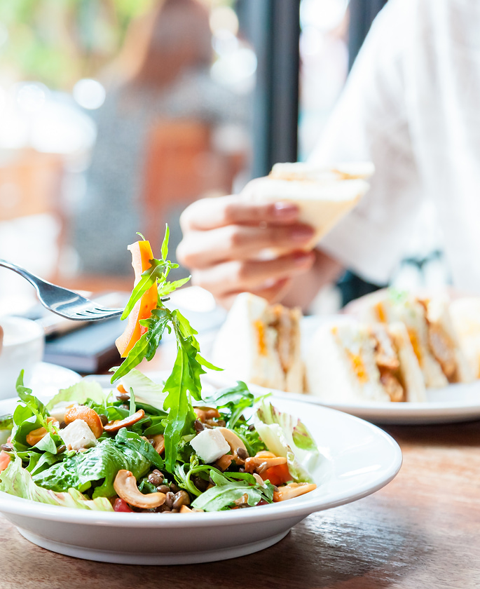 Fresh healthy salad served with sandwich and refreshing drink