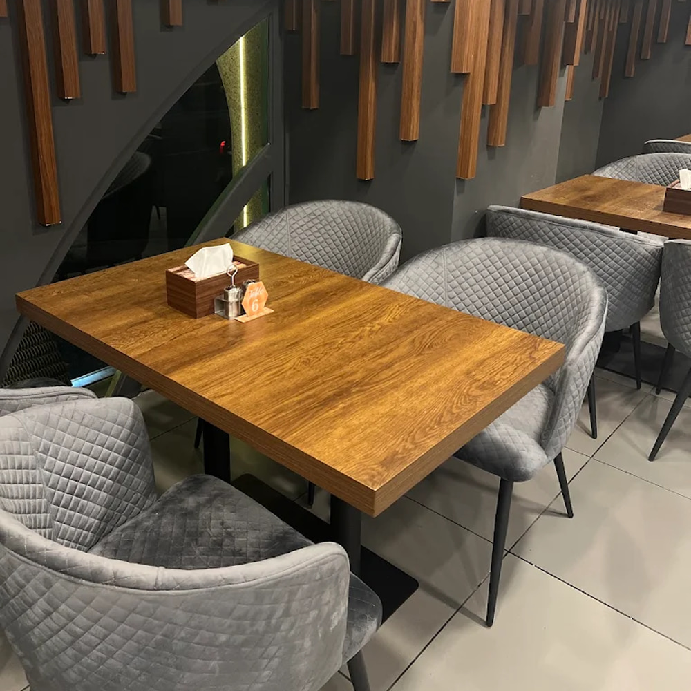 Modern restaurant seating area with wooden tables and gray chairs