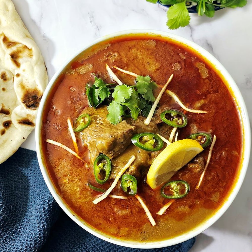 Spicy Iranian curry garnished with herbs and green chilies